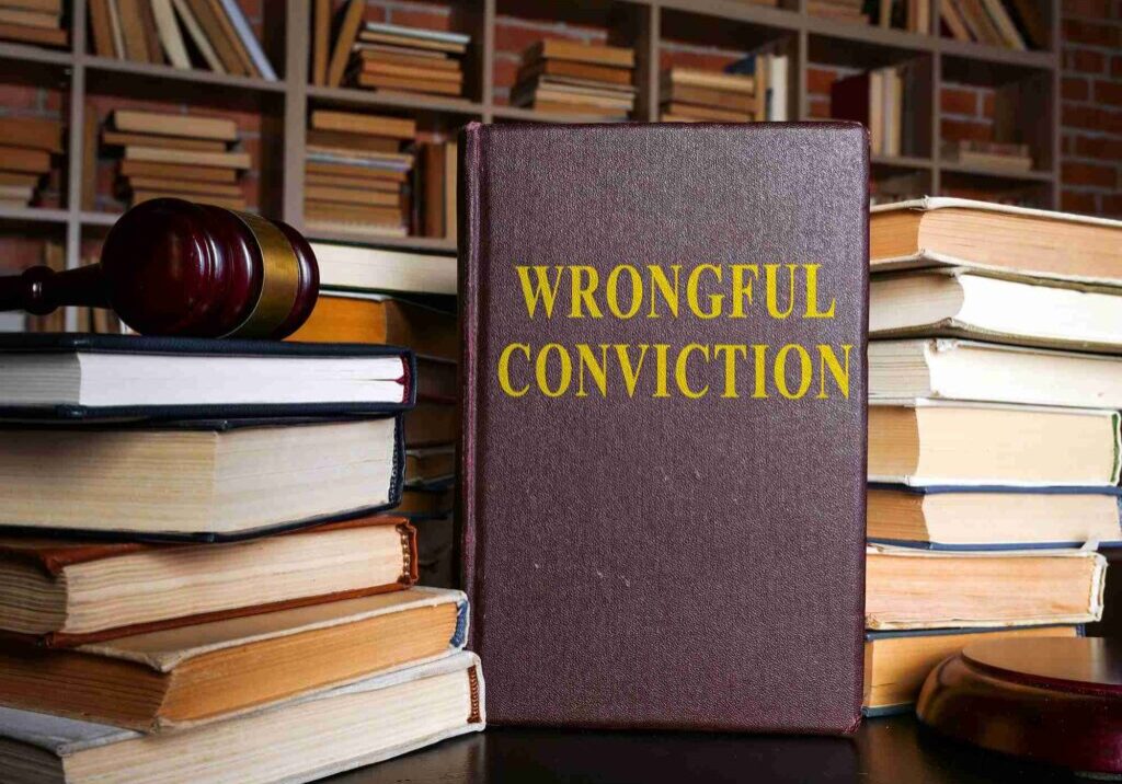 Book titled 'Wrongful Conviction' on a desk with law books and a gavel.